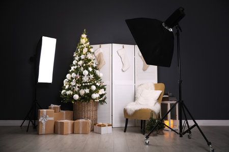 Beautiful photo zone with professional equipment and decorated Christmas treeの写真素材