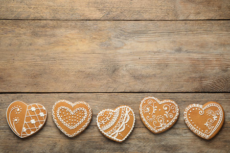 Decorated gingerbread hearts on wooden table, flat lay. Space for textの写真素材