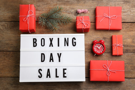 Flat lay composition with Boxing Day Sale sign and Christmas gifts on wooden tableの写真素材