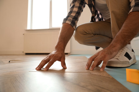 Professional worker installing new parquet flooring indoors, closeupの写真素材