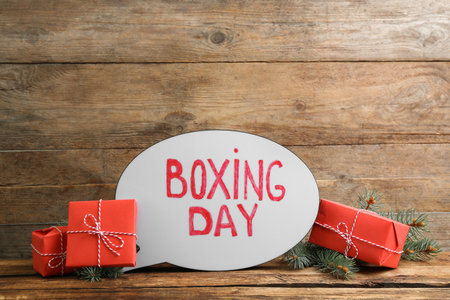 Composition with Boxing Day sign and Christmas gifts on wooden tableの写真素材