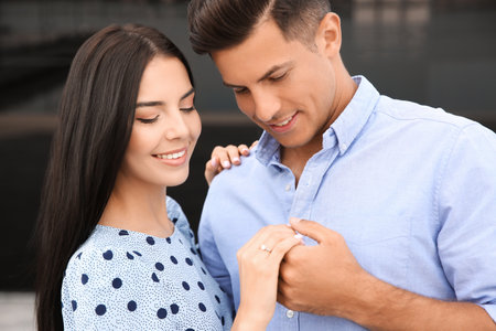 Lovely couple looking at beautiful engagement ring outdoorsの写真素材