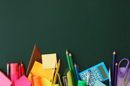 Flat lay composition with different school stationery on green chalkboard, space for text. back to schoolの写真素材