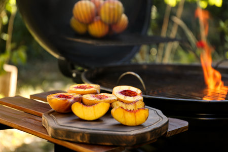 Delicious grilled peaches on wooden table outdoorsの写真素材