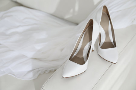 Classic white wedding shoes on sofa indoorsの写真素材