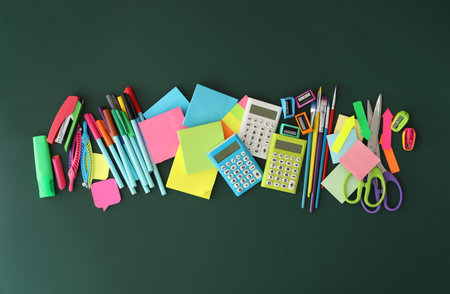 Flat lay composition with different school stationery on green chalkboard. back to schoolの写真素材