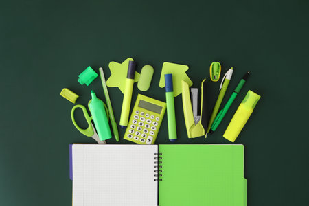 Flat lay composition with different school stationery on green chalkboard. back to schoolの写真素材