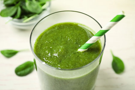 Delicious fresh green juice with straw in glass, closeupの写真素材