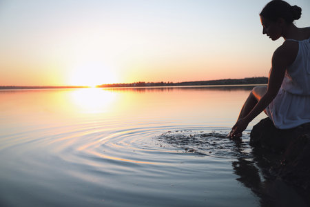 woman near river at sunset. Healing conceptの写真素材