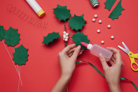 Woman making mistletoe branch on red background, top viewの写真素材