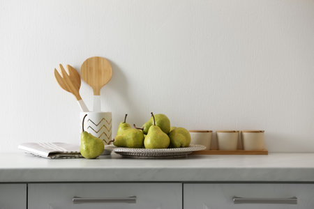 Plate with fresh ripe pears on white countertopの写真素材