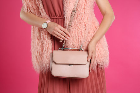 Young woman with stylish bag on pink background, closeupの写真素材