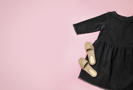 Stylish black dress and shoes on pink background, flat lay. Space for textの写真素材