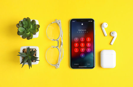MYKOLAIV, UKRAINE - JULY 10, 2020: Flat lay composition with Iphone 11 and AirPods on yellow...