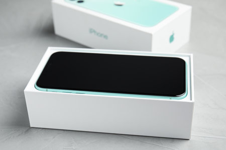 MYKOLAIV, UKRAINE - JULY 10, 2020: New modern Iphone 11 in original box on light gray tableのeditorial素材