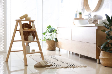 Dispensers and different toiletries on decorative ladder in bathroom. Idea for interior designの写真素材