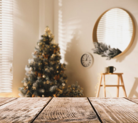 Empty wooden surface and blurred Christmas tree in room on background, bokeh effect. space for designの写真素材