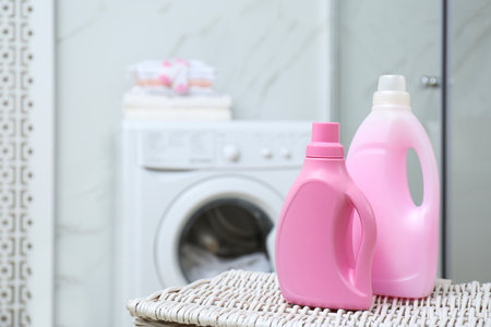 Bottles of detergent on wicker basket in bathroom. Space for textの写真素材
