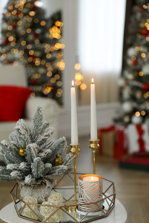 Beautiful Christmas composition with burning candles on table indoorsの写真素材