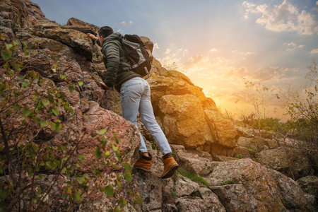 Hiker with backpack climbing up mountain on autumn dayの写真素材
