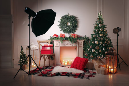 Beautiful Christmas themed photo zone with professional equipment and fireplaceの写真素材
