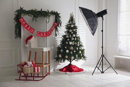 Beautiful photo zone with professional equipment and decorated Christmas treeの写真素材