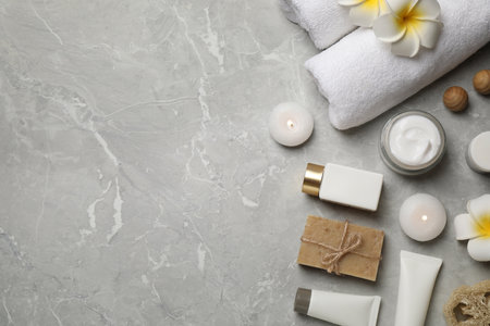 Flat lay composition with towels and skin care products on light gray marble background, space for textの写真素材