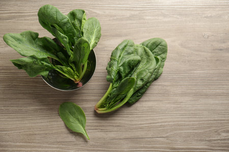 Fresh healthy green spinach leaves on wooden table, flat layの写真素材