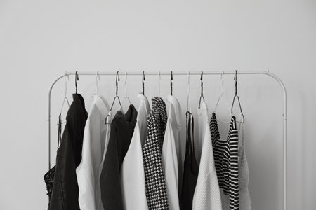 Rack with stylish clothes near white wall, closeupの写真素材