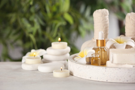 Beautiful composition with aroma oil and spa stones on table. Space for textの写真素材