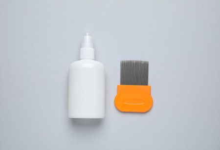 Spray and metal comb for anti lice treatment on light gray background, flat layの写真素材