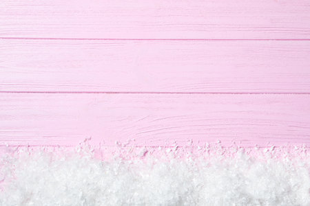 Heap of snow and space for text on pink wooden background, top view. christmas timeの写真素材