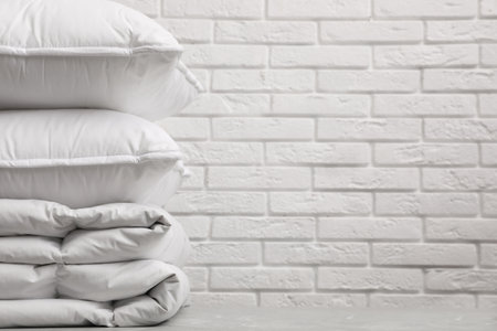 Soft folded blanket and pillows on table, closeup. Space for textの写真素材