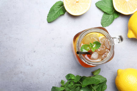Delicious iced tea with lemon and mint on gray table, flat lay. Space for textの写真素材