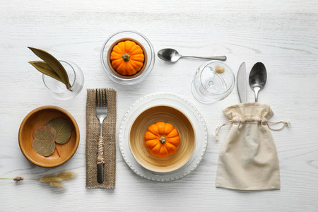 Autumn table setting with pumpkins on white wooden background, flat layの写真素材