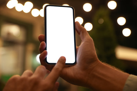 Man using modern mobile phone outdoors at night, closeupの写真素材