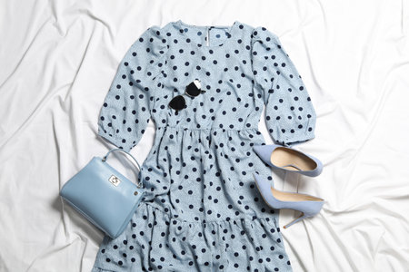 Flat lay composition with stylish blue dress on white fabricの写真素材