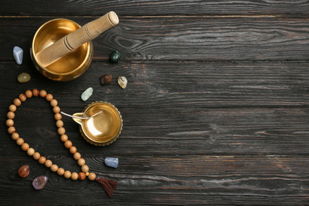 Flat lay composition with golden singing bowl on black wooden table, space for text. sound healingの写真素材