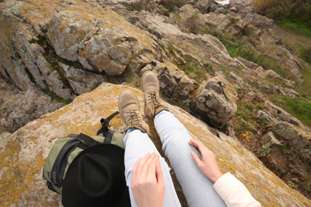 Woman with backpack on steep cliff, closeupの写真素材