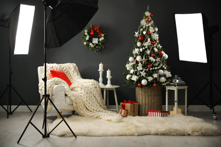 Beautiful photo zone with professional equipment and decorated Christmas treeの写真素材