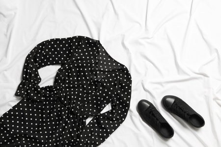 Stylish black dress and shoes on white fabric, flat layの写真素材