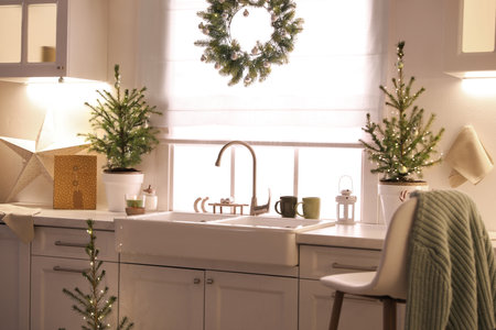Small Christmas trees and festive decor in the kitchenの写真素材
