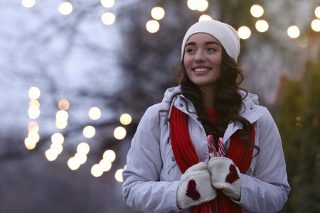 Happy young woman with candy canes on city street in the evening. christmas celebrationの写真素材
