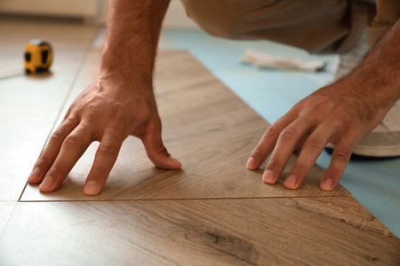 Professional worker installing new parquet flooring indoors, closeupの写真素材