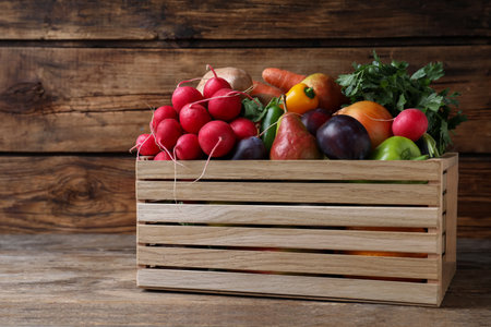 Crate full of different vegetables and fruits on wooden table. Harvesting timeの写真素材