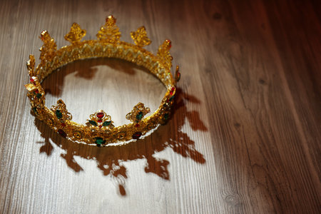 Beautiful golden crown with gems on wooden table. fantasy itemの写真素材