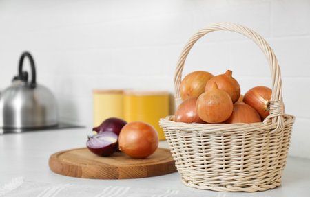 Fresh cut and whole onions on white countertop in modern kitchenの写真素材
