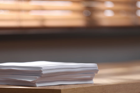 Stack of blank paper on wooden table indoors. Space for textの写真素材