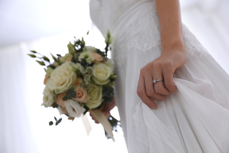 Young bride with beautiful wedding bouquet on light background, closeupの写真素材