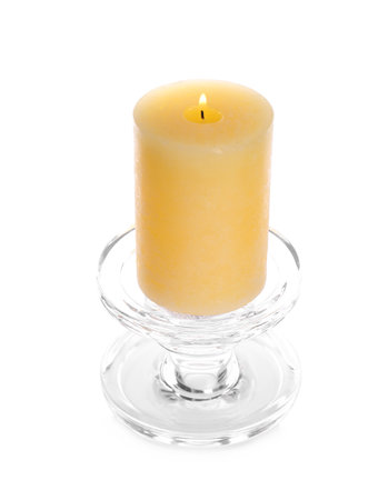 Burning yellow wax candle isolated on whiteの写真素材